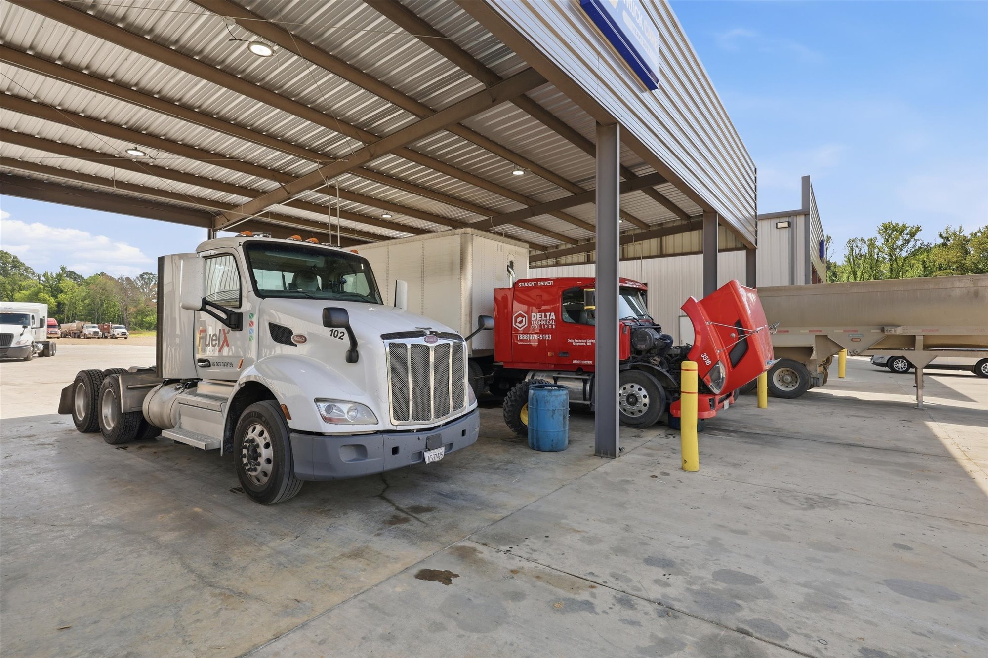 Multiple fleet trucks under the Wilkerson's Diesel & Tire service canopy in Jackson, MS